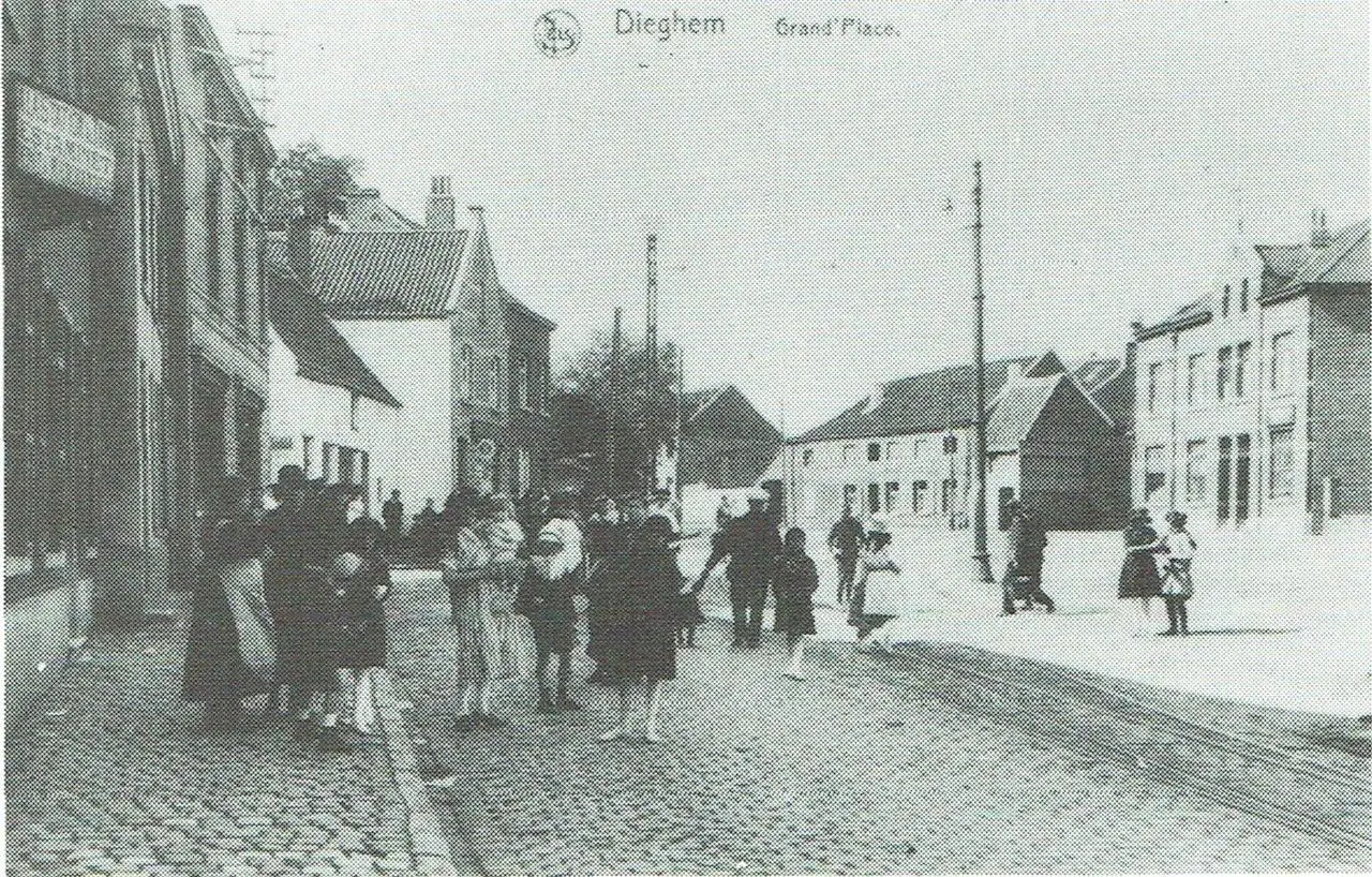 De Plaats op de verbrede Haachtsesteenweg; uiterst links «A la Station du Tram – Estaminet – Dépôt de Marchandises», later fotograaf Arthur Peeters.
