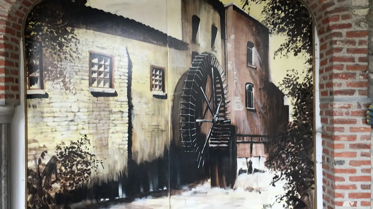 Schilderij van het waterrad tegen een bakstenen muur.
