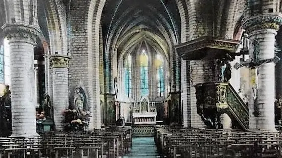 Het schip van de kerk met glasramen en preekstoel.